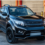 Black Nissan truck parked in front of a building with a red door with Lazer Lamps Nissan Navara (2014-2021) Kit