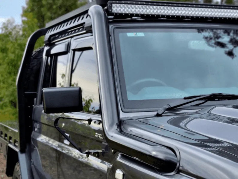 Close-up of a vehicle with a roof rack and additional lights, outdoors.