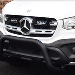 Front view of a white Mercedes-Benz vehicle with a black grille guard on a dark surface with Lazer Lamps Mercedes X-Class (2017+) Grille Kit