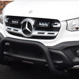 Front view of a white Mercedes-Benz vehicle with a black grille guard on a dark surface with Lazer Lamps Mercedes X-Class (2017+) Grille Kit