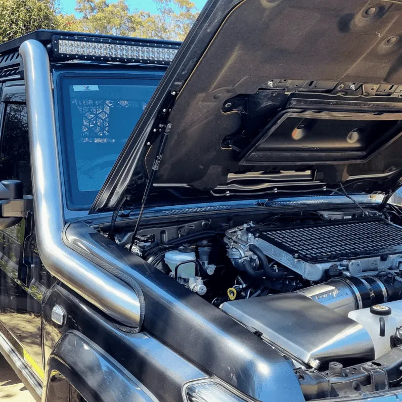 Close-up of a vehicle's open hood with engine components visible