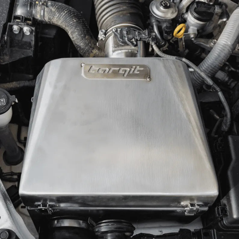 Metallic engine component with 'Torqit' branding in an engine bay.