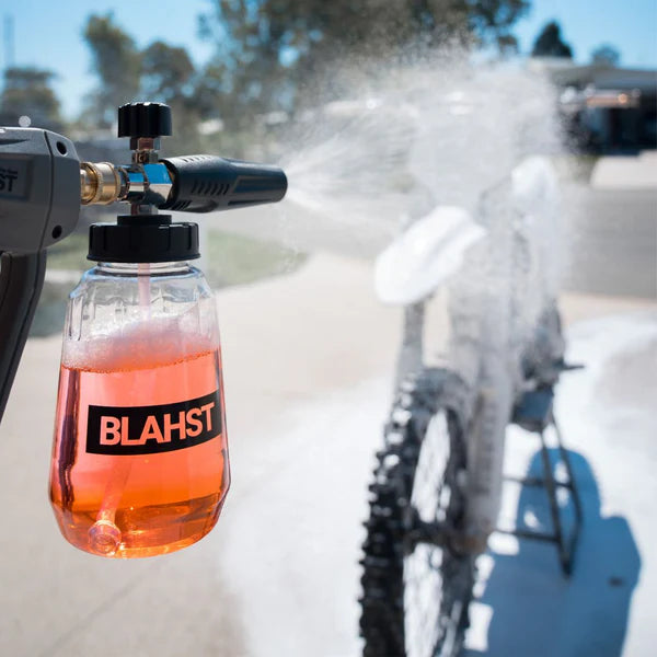 BLAHSST cleaning solution being sprayed onto a bike with a blurred background