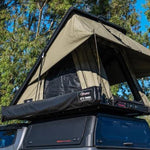 Roof top tent attached to a vehicle with trees in the background