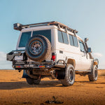 White off-road vehicle with a spare tire on a desert landscape