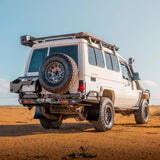 White off-road vehicle with a spare tire on a desert landscape
