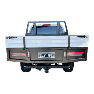 Back view of a truck with a flatbed and license plate on a white background – Dual Cab 1800mm Aluminium Tray with 1m Trundle Drawer 50L Water tank & Colour Coded Tray Sides