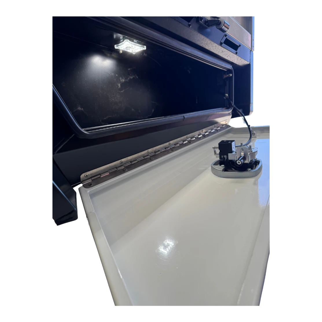 Inside the tray toolbox with the lid raised, an LED strip lighting the compartment, the full-length stainless piano hinge along the base, and the water tank filler and sender unit mounted on the white tank alongside
