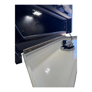 Inside the tray toolbox with the lid raised, an LED strip lighting the compartment, the full-length stainless piano hinge along the base, and the water tank filler and sender unit mounted on the white tank alongside