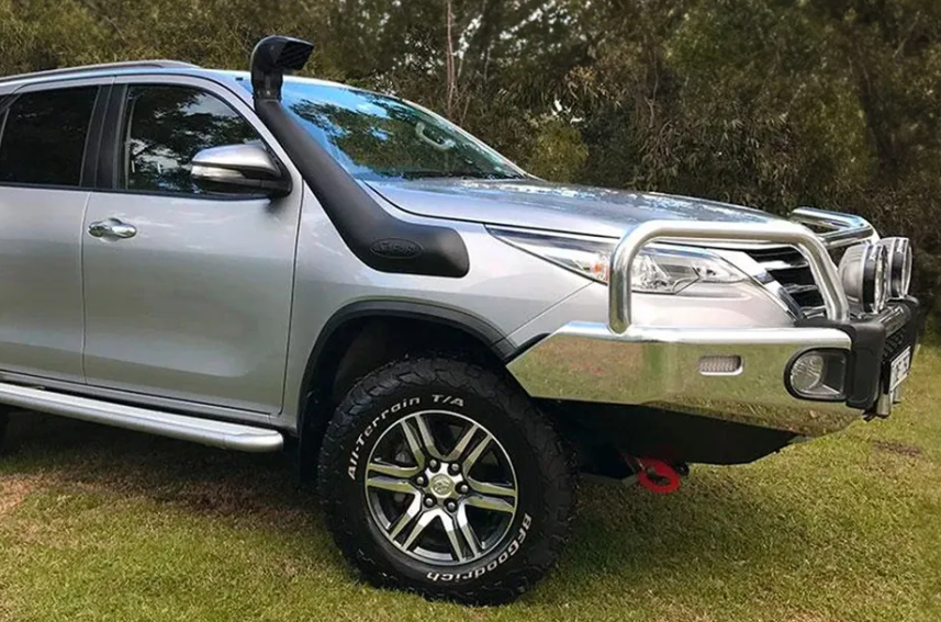 Silver SUV with off-road features on a grassy area