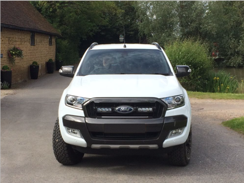 White Ford ranger with Lazer Lamps Grille Kit (2016–2018) parked on a driveway with a house and trees in the background