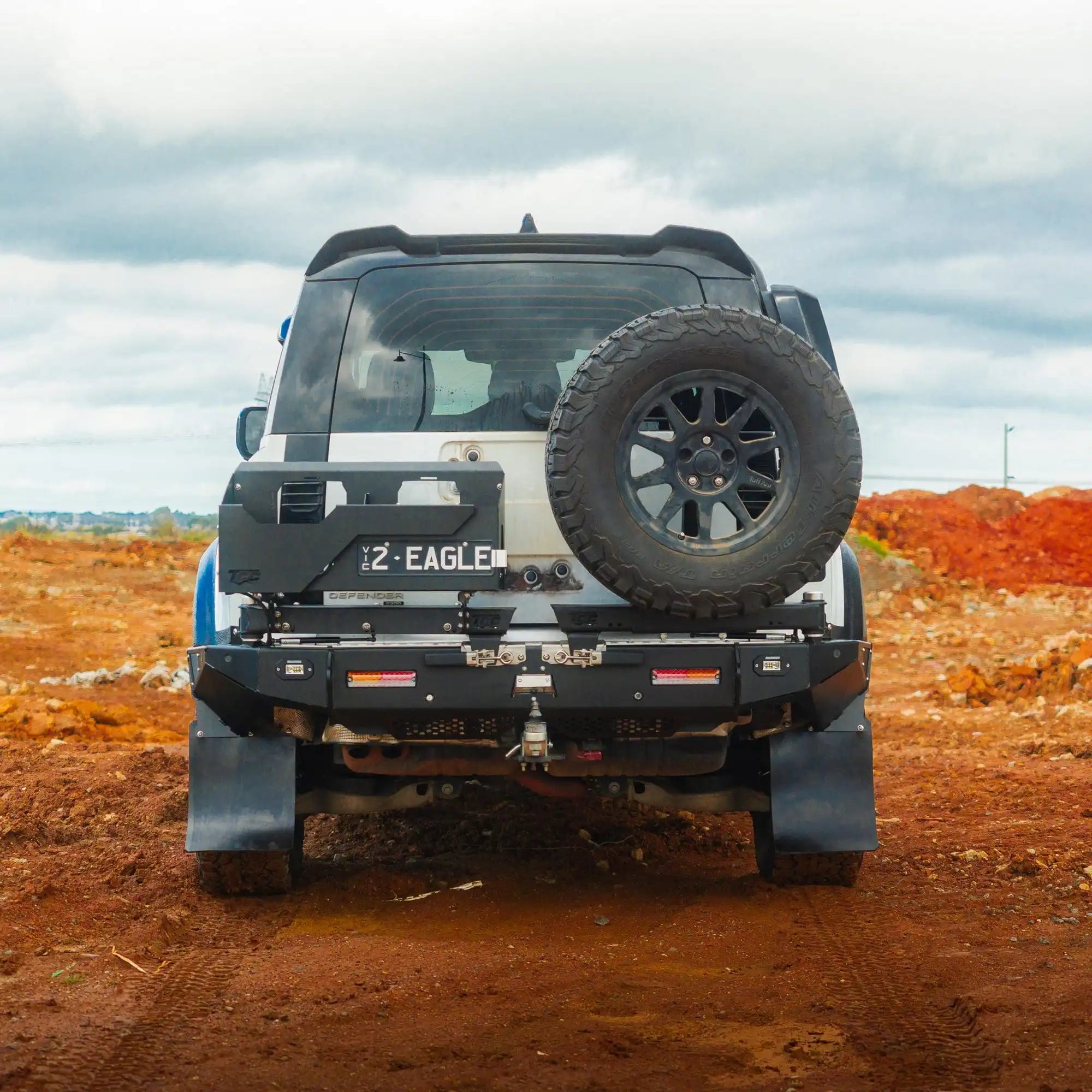 Off-road vehicle on a dirt road with a cloudy sky