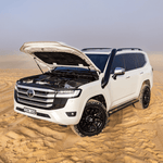 White Toyota SUV with open hood in a desert setting