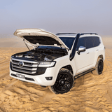 White Toyota SUV with open hood in a desert setting