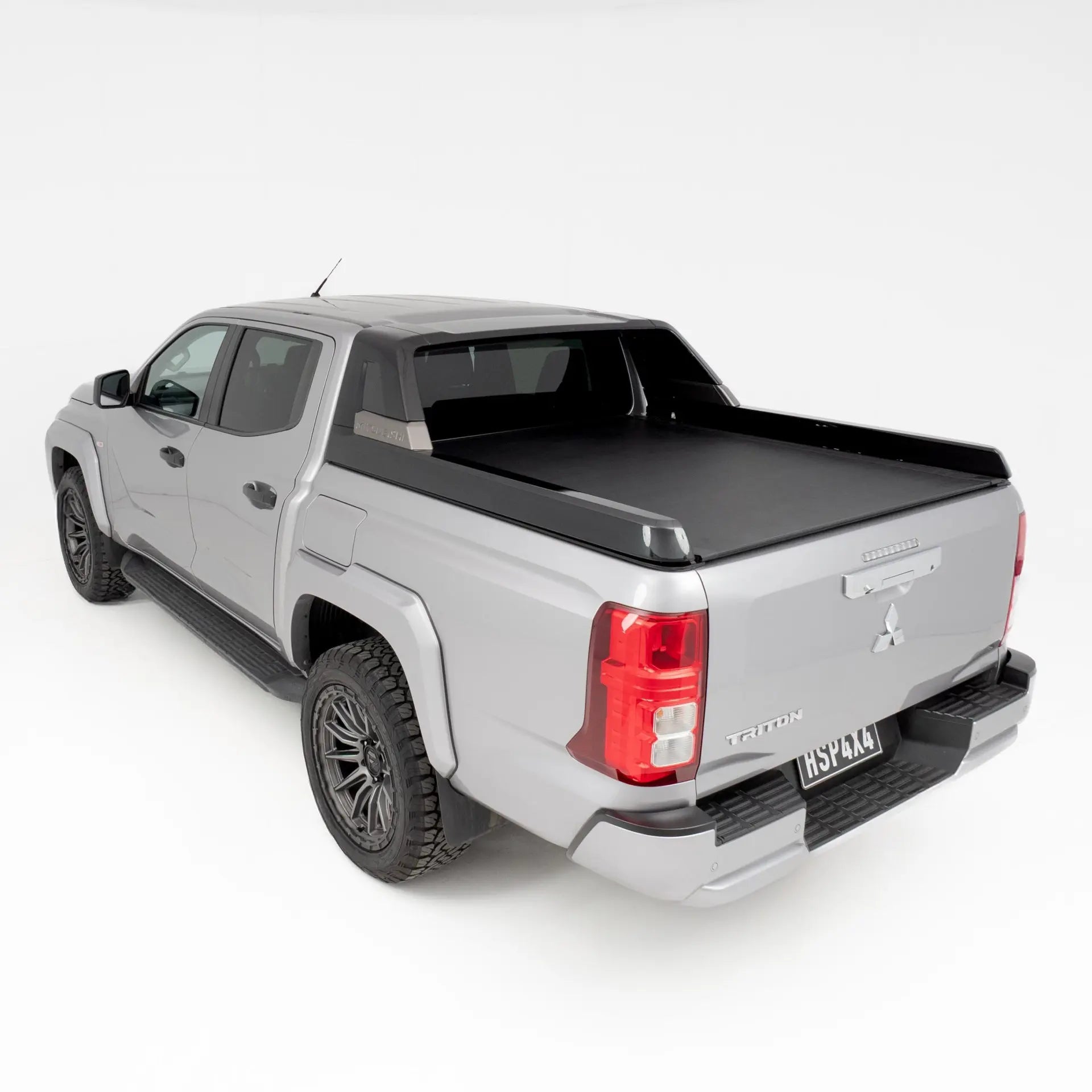 Silver pickup truck with a black tonneau cover on a white background