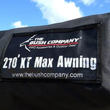 Black awning with 'The Bush Company' branding against a blue sky and green trees.