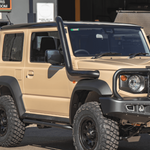 Beige off-road vehicle with black roof rack and bumper in a showroom setting