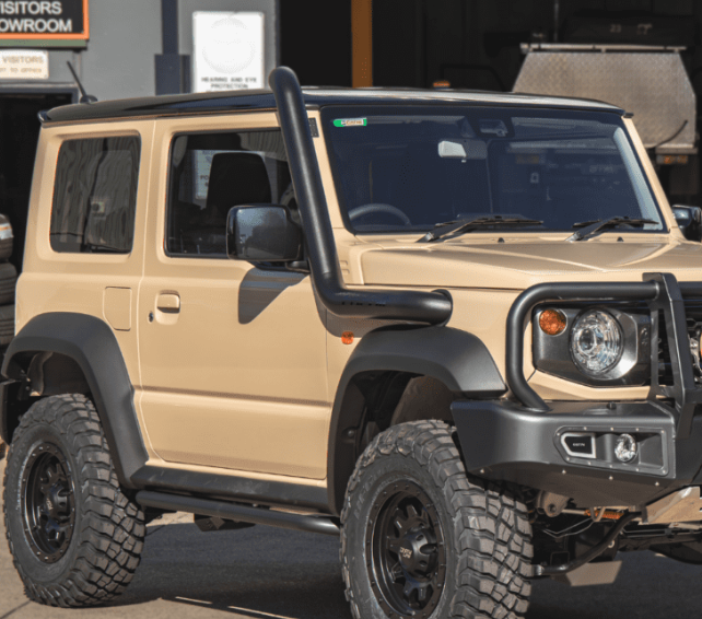 Beige off-road vehicle with black roof rack and bumper in a showroom setting