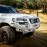 White off-road vehicle on a dirt road with trees in the background