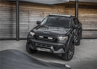 Black off-road vehicle with additional Lazer Lamps Roof Mount Kit – Ford Ranger (2016+ No Roof Rails) lights in front of a wooden wall.