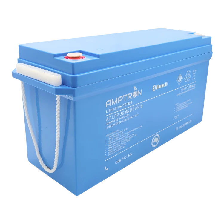 The same 36 volt 85Ah Amptron battery from the front corner with its rope carry handle lifted clear of the case, showing the depth of the housing and the recessed terminals