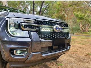 Ford vehicle grille with lazerLamps Grille Kit and trees in the background