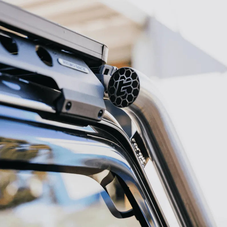 Close-up of a car roof rack system with visible branding on a vehicle.