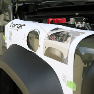 Car fender with a repair kit labeled 'torqit' on a car with an open hood.