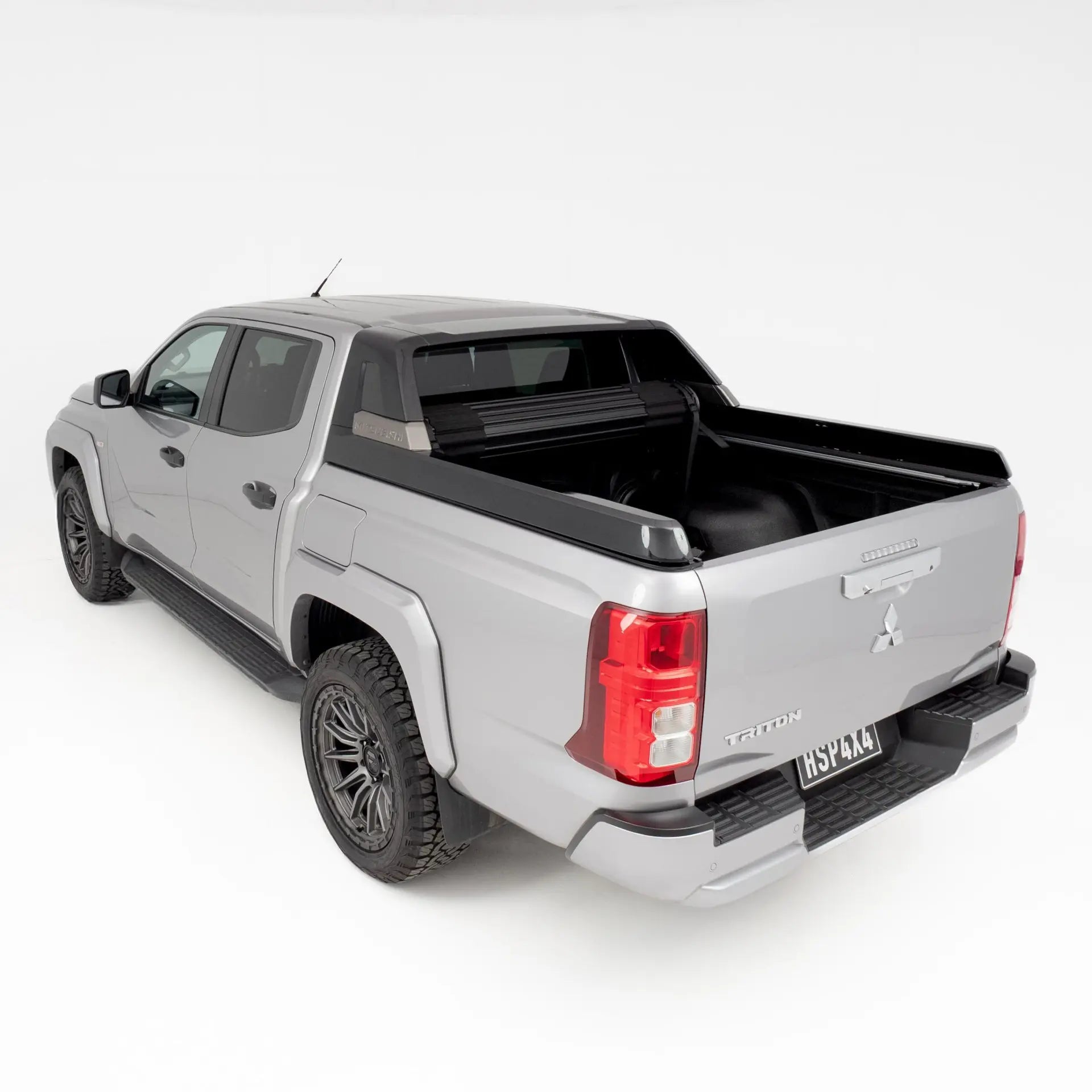 Silver pickup truck with a black tonneau cover on a white background