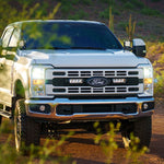 White Ford truck on a dirt road with desert landscape and Lazer Lamps Grille Kit – Ford F-250 & F-350 XL/XLT (2023+)
