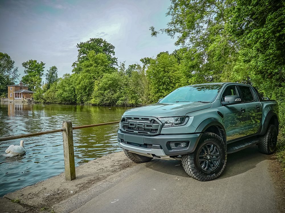 Green ford ranger raptor parked by a river with trees in the background with Lazer Lamps Grille Kit – Ford Ranger Raptor (2018–2022)