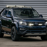 Black Volkswagen Amarok pickup truck with additional lights on a gray background with Lazer Lamps Grille Kit for VW Amarok V6 (2016–2022)