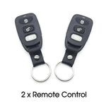 Two black remote controls with keychains on a white background
