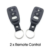 Two black remote controls with keychains on a white background