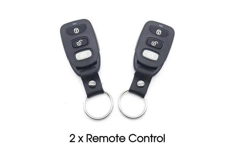 Two black remote controls with keychains on a white background