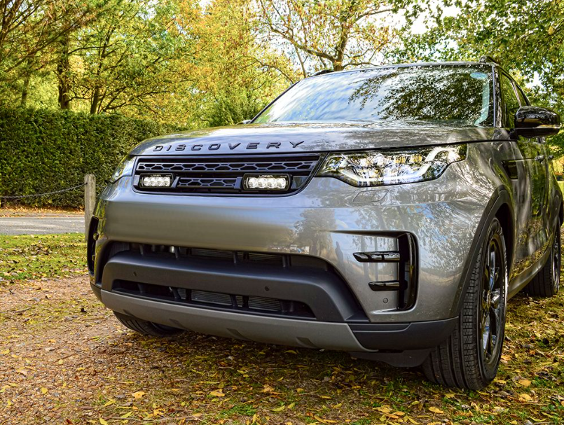 Land Rover Discovery SUV parked on a dirt road with trees in the background