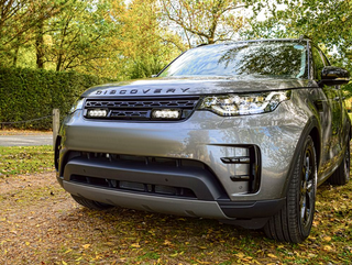 Land Rover Discovery SUV parked on a dirt road with trees in the background