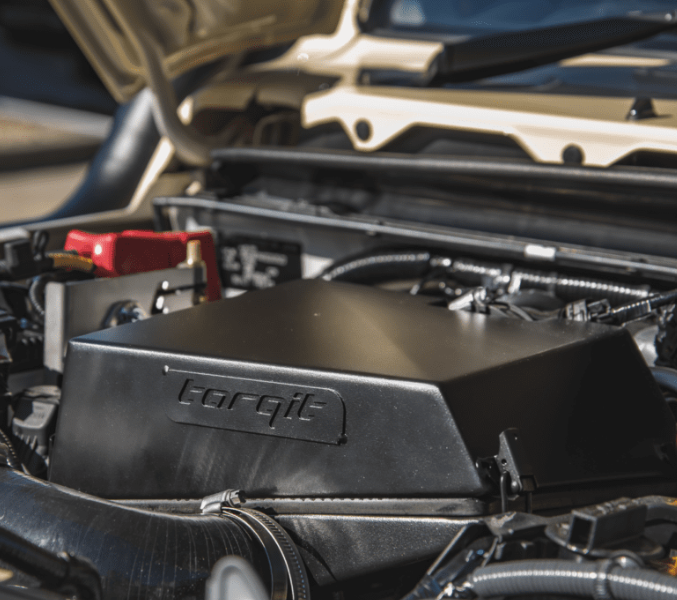 Engine compartment of a vehicle with 'Torqit' branding on a blurred background