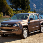 Brown Volkswagen Amarok pickup truck parked by a lake with mountains in the background with Lazer Lamps Grille Kit for VW Amarok (2011–2015)
