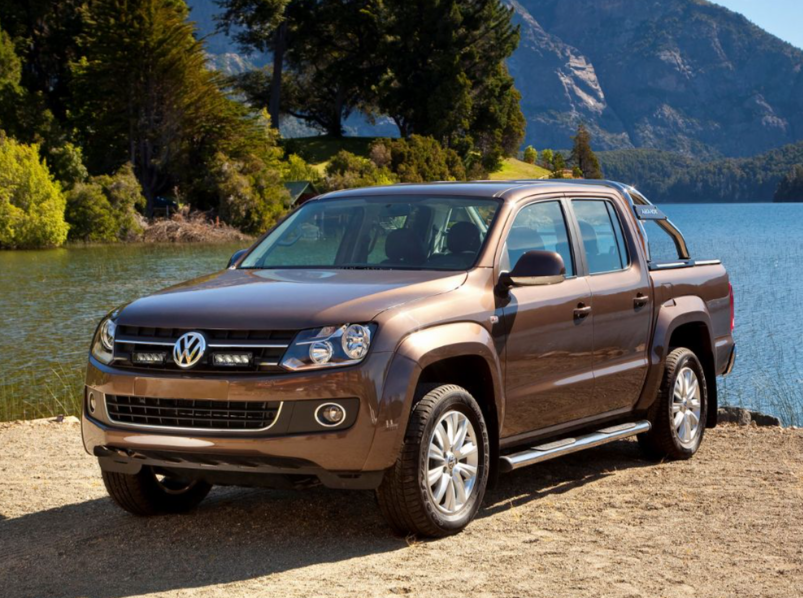 Brown Volkswagen Amarok pickup truck parked by a lake with mountains in the background with Lazer Lamps Grille Kit for VW Amarok (2011–2015)
