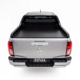 Back view of a silver Mitsubishi Triton pickup truck with a tonneau cover on a white background