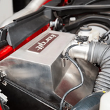 Close-up of a car engine with a 'torqit' branded component.