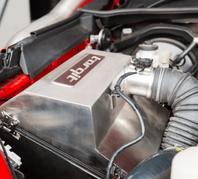 Close-up of a car engine with a 'torqit' branded component.