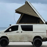 Van with an extended roof tent on a beach