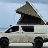 Van with an extended roof tent on a beach