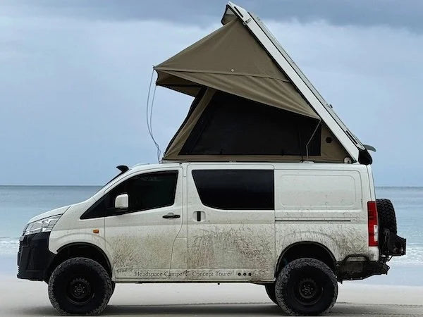 Van with an extended roof tent on a beach