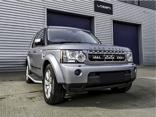 Silver Land Rover parked in front of a building with 'Latan' branding.