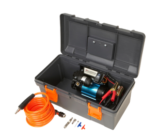ARB single piston compressor in its grey plastic travel case with the lid open, the compressor mounted inside with its battery clamps, and the orange coiled air hose, tyre chuck and inflation adaptors laid out in front