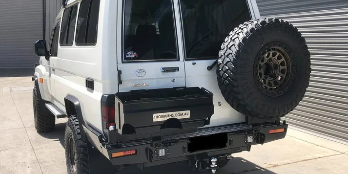 White off-road vehicle with a Thorburns LC75/78 Rear Bar mounted on a concrete surface.