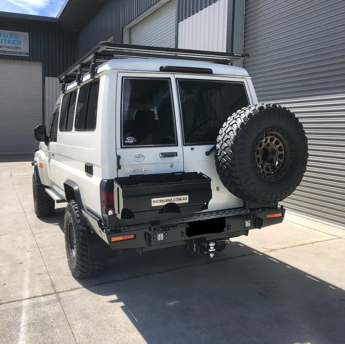 White off-road vehicle with a Thorburns LC75/78 Rear Bar mounted on a concrete surface.